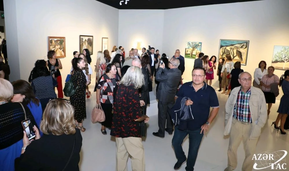 Visitors moving through the large galleries of Back in Baku at the Heydar Aliyev Center.