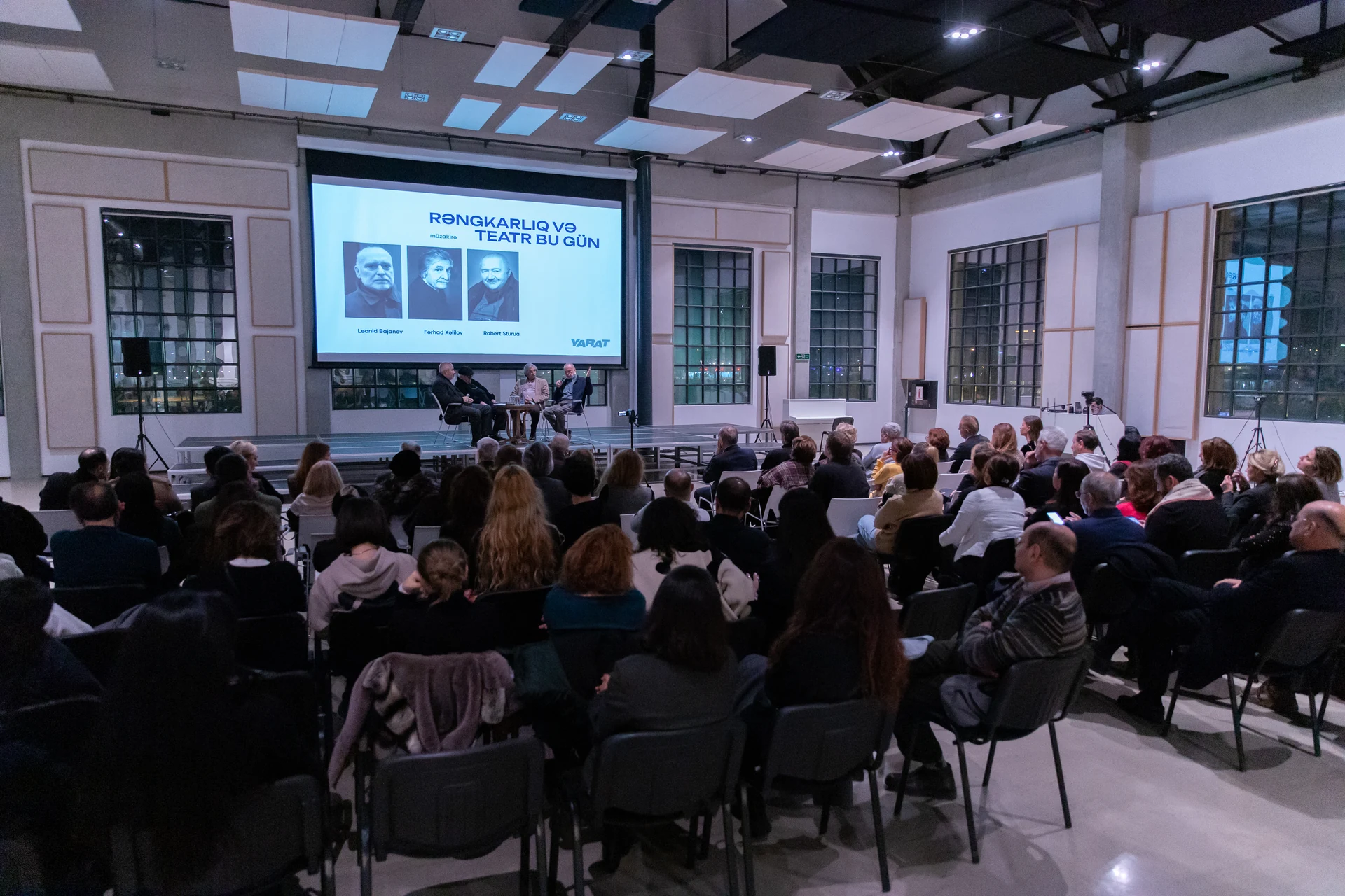 A wide view of the seated audience and discussion panel at the YARAT creative evening.