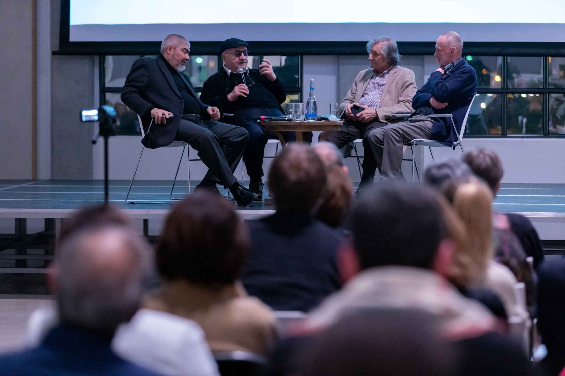 Robert Sturua addresses the panel, with audience members in the foreground.