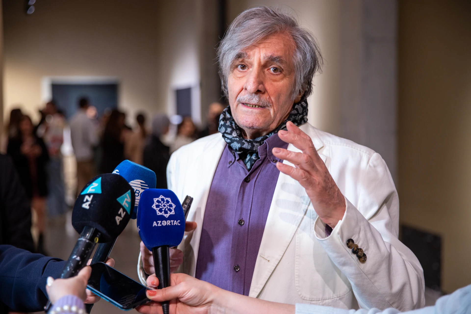Farhad Khalilov speaks to television reporters during the opening of Between the Earth and the Sky.