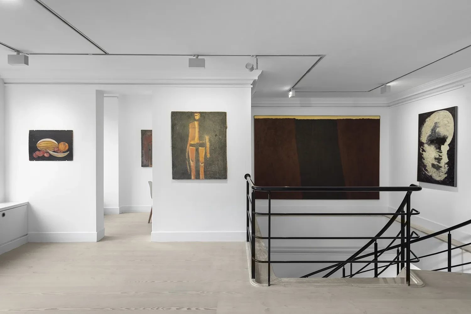 Upper-floor installation of The New Verge, with paintings by Ashraf Murad and Farhad Khalilov beside the staircase railing.