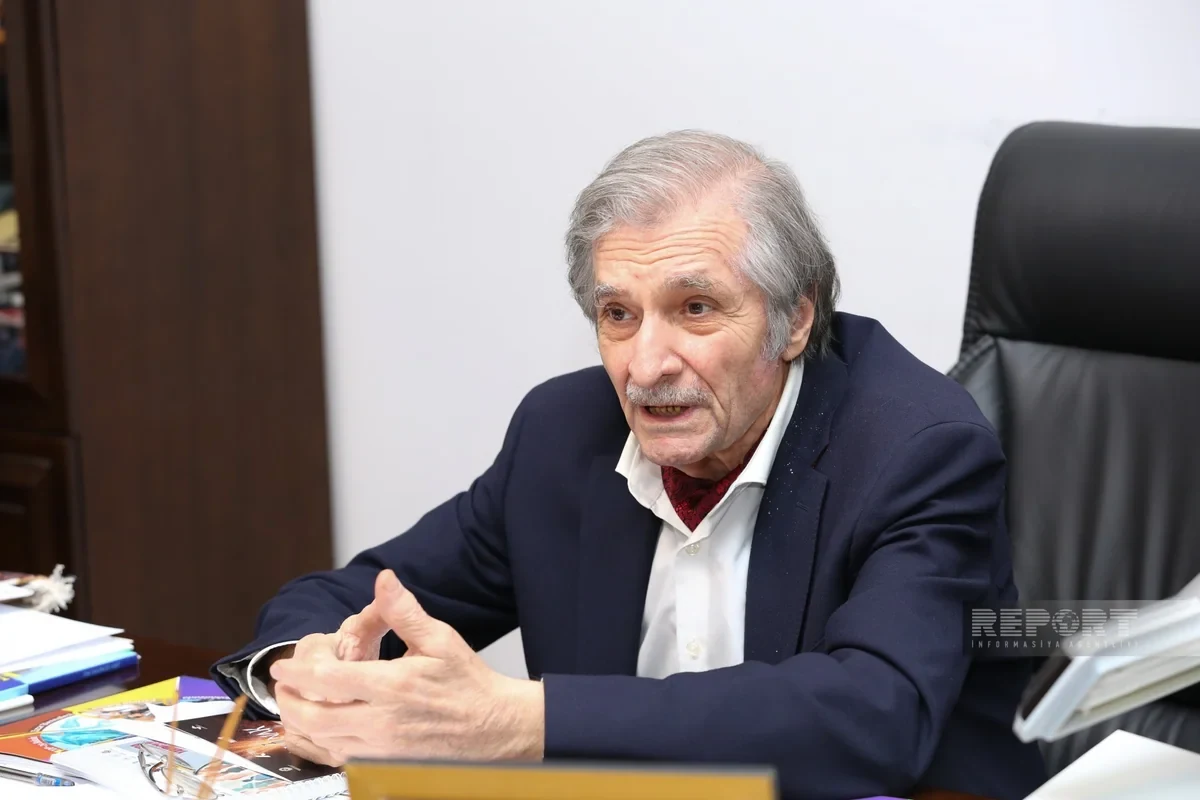 Farhad Khalilov speaking with his hands together at his desk in the Artists' Union.