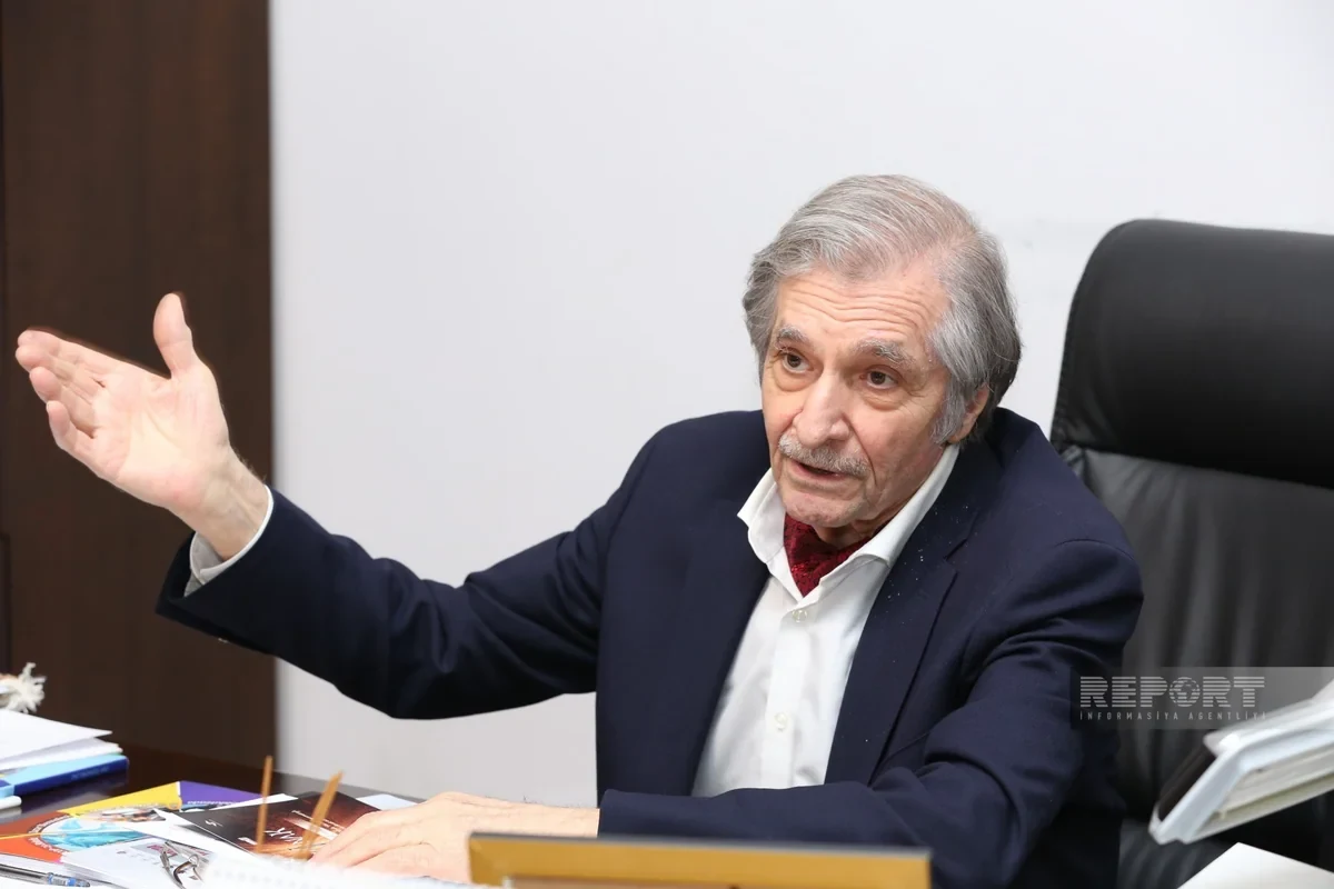 Farhad Khalilov extending his arm as he responds to a question in the interview.